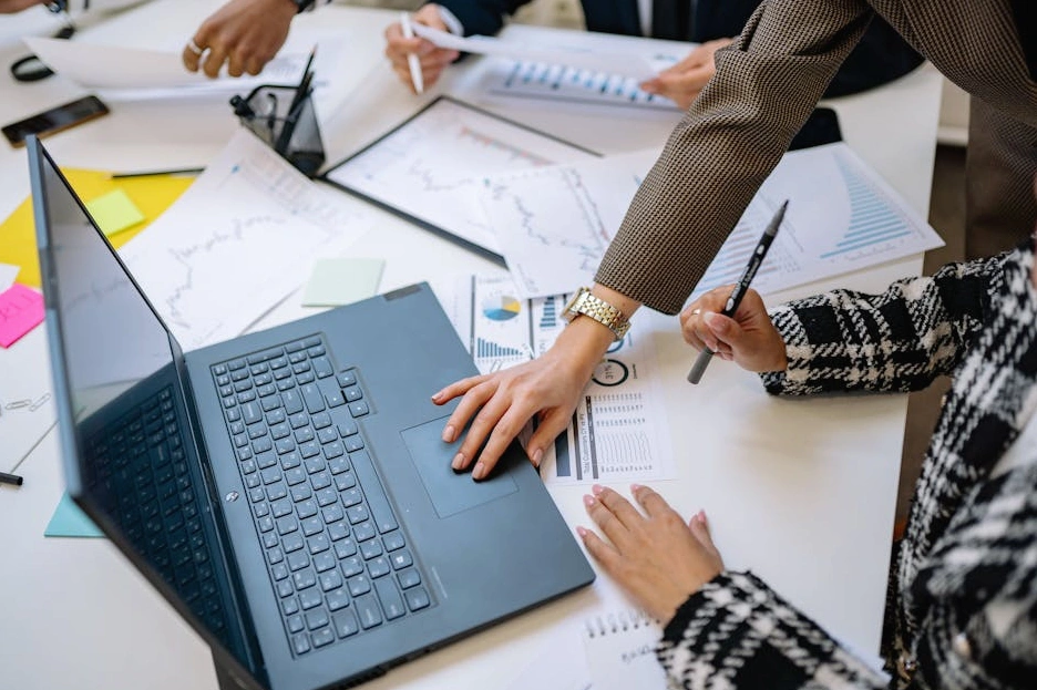 A focused professional analyzing financial data on a laptop in a modern office.